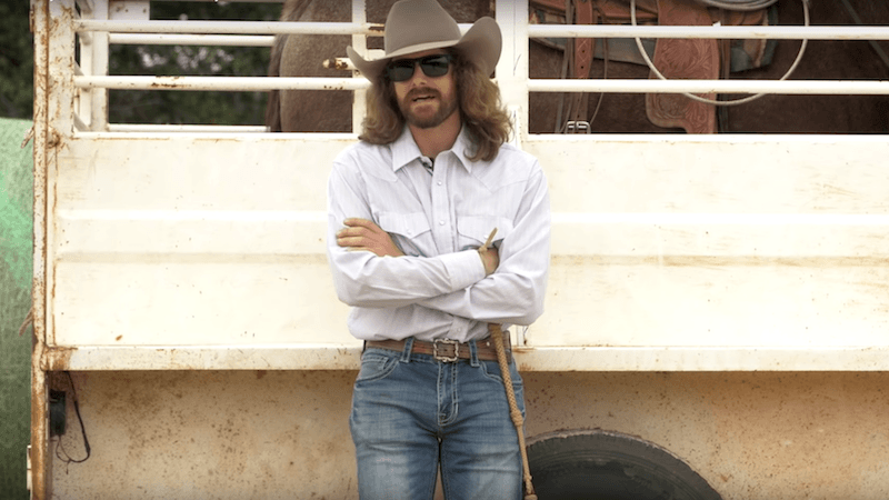 Dale Brisby leaning up against horse trailer