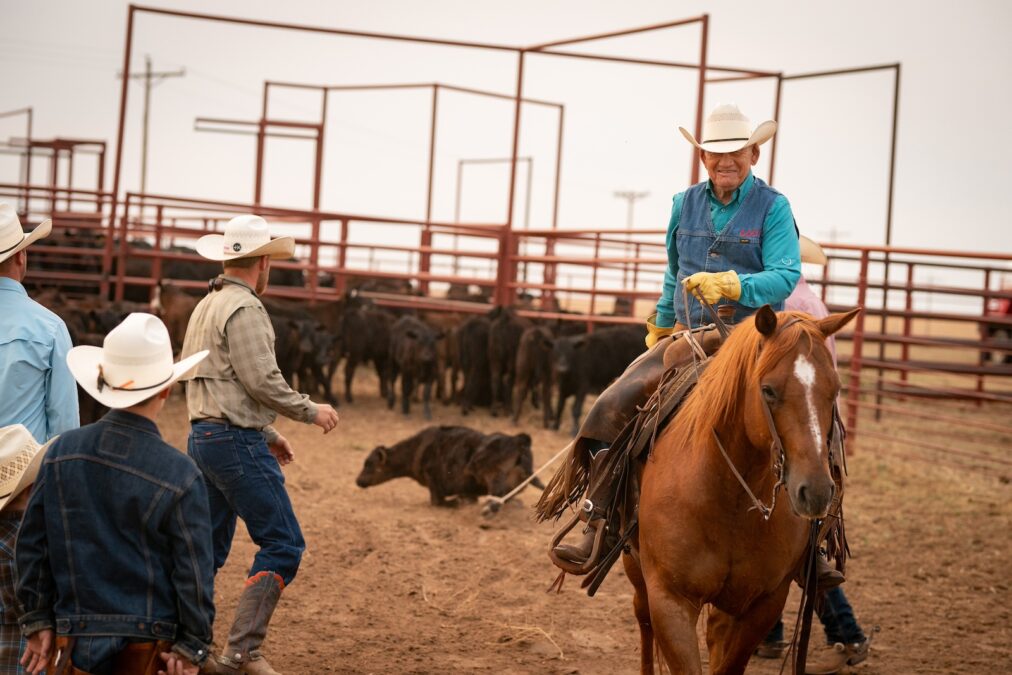 O'Neal smiles while dragging a calf to the fire for branding. 